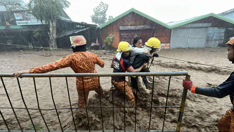 In this handout photo taken on November 5, 2025 and received from the Bureau of Fire Protection-Canlaon (BFP-CANLAON), firemen rescue a woman amidst surging flood waters due to heavy rains brought about by Typhoon Kalmaegi along a street in Canlaon City, Negros Oriental, central Philipines. The death toll from Typhoon Kalmaegi in the Philippines climbed to 66 on November 5 as residents of hardest-hit Cebu province began picking through homes and businesses devastated by the worst flooding in recent memory.