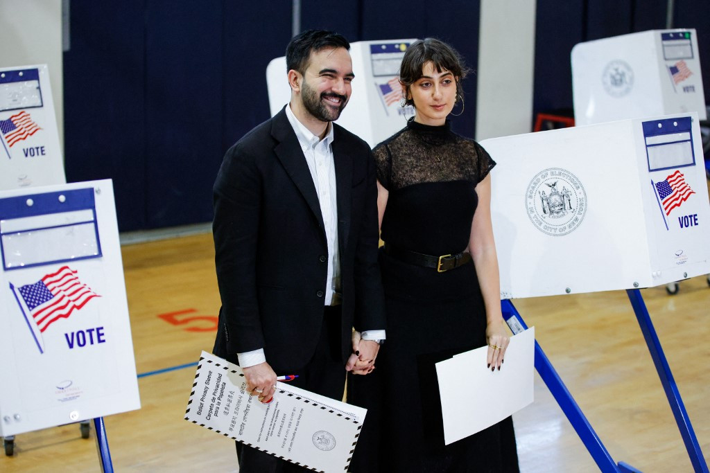 Democratic New York City mayoral candidate Zohran Mamdani holds hands with his wife Rama Duwaji after they voted at a polling location at Frank Sinatra School of Arts in the Queens borough of New York City on November 4, 2025. 
