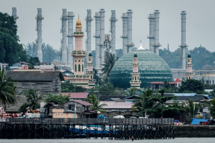 An oil refinery is seen behind a mosque on July 9, 2024, in Balikpapan, East Kalimantan.
