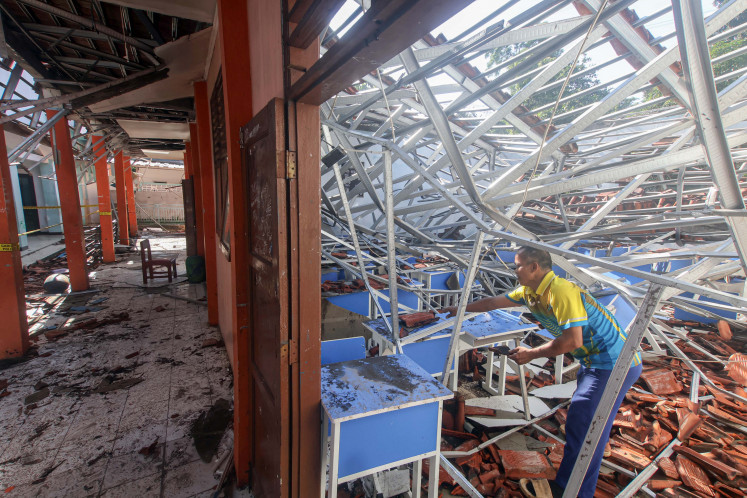 Systemic breakdown?: An employee looks for salvageable items on Nov. 4, 2025, in a collapsed classroom at SMKN 1 Gunung Putri in Bogor regency, West Java, the day after heavy rain and strong winds damaged five buildings and injured 42 students at the vocational senior high school.