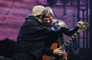 Liam (left) and Noel Gallagher of the legendary Britpop band share a hug during Oasis’ show on Oct. 25, 2025, at the Tokyo Dome.