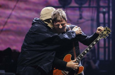 Liam (left) and Noel Gallagher of the legendary Britpop band share a hug during Oasis’ show on Oct. 25, 2025, at the Tokyo Dome.