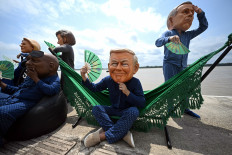 Oxfam activists wearing oversized masks representing (from left to right) European Commission President Ursula Von der Leyen, South Africa's President Cyril Ramaphosa, Argentina's President Javier Milei, US President Donald Trump and Canada's Prime Minister Mark Carney pose during their “Big Heads“ protest stunt at the riverbank of the Federal University of Para in Belem, Brazil, on November 5, 2025 on the sidelines of the COP30 UN Climate Summit.