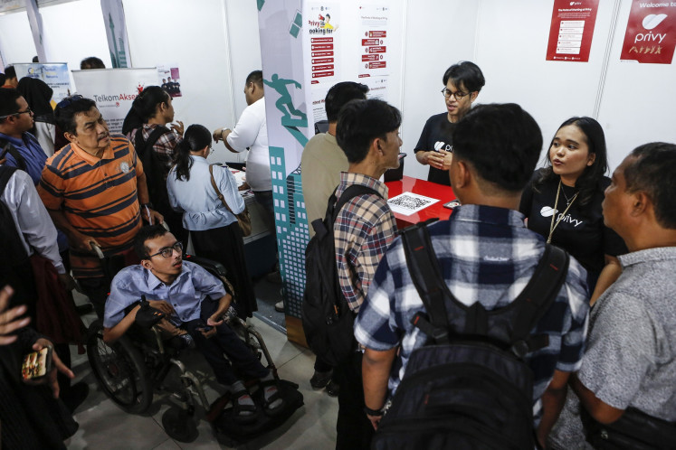 People with disabilities visit booths during a job fair designated for people who are disabled at the Taman Ismail Marzuki in Central Jakarta on Nov. 3, 2025. The job fair offered 107 positions specially designated for disabled people.