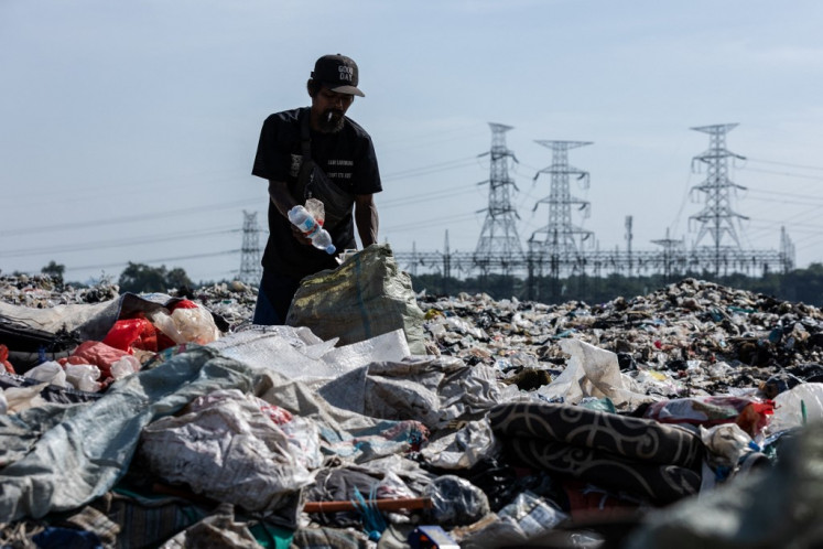 A man collects used items including plastic bottles on Sept. 2, 2025 at the Cipeucang landfill, where the local administration plans to build a waste-to-energy plant to burn waste and generate electricity, in South Tangerang, Banten.