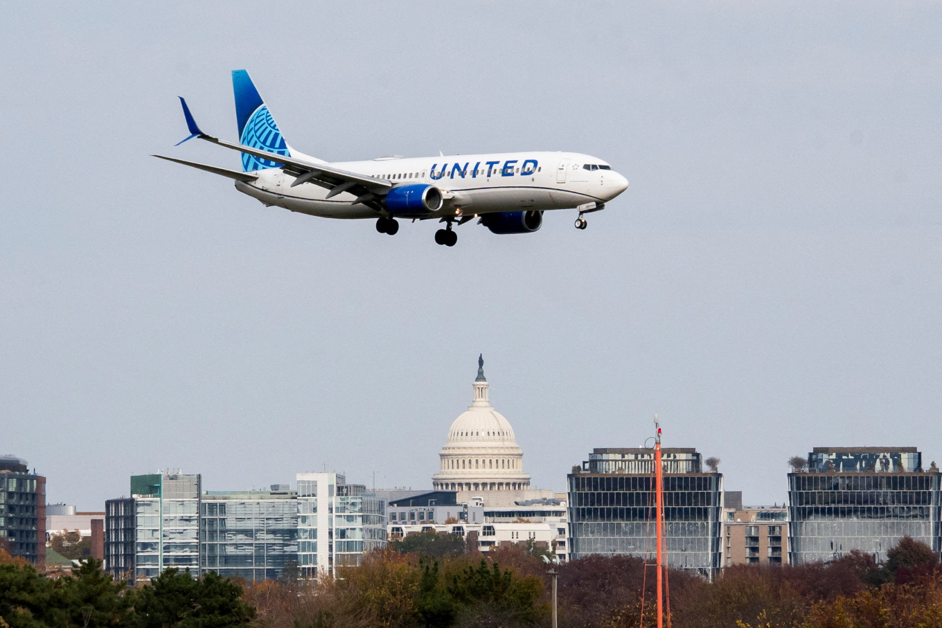 A United Airlines flight lands in front of the US Capitol at Ronald Reagan Washington National Airport as the Trump administration warns of impending cuts to commercial airline operations more than a month into the continuing US government shutdown in Arlington, Virginia, US, on Nov. 7, 2025.