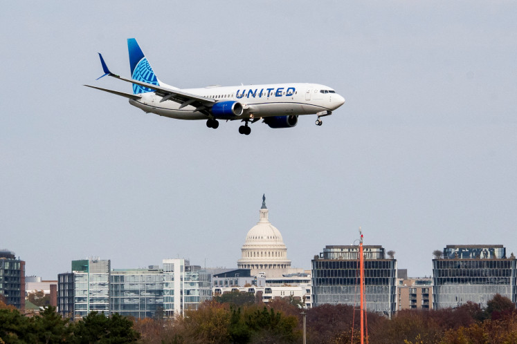 A United Airlines flight lands in front of the US Capitol at Ronald Reagan Washington National Airport as the Trump administration warns of impending cuts to commercial airline operations more than a month into the continuing US government shutdown in Arlington, Virginia, US, on Nov. 7, 2025.