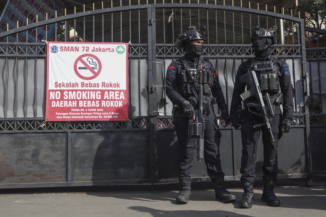 Two personnel of the Jakarta Police's Gegana (bomb squad) stand guard on Nov. 7 in front of the gate of SMAN 72 Jakarta state senior high school in Jakarta. Ninety-six people were injured in two blasts on Nov. 7 inside a mosque at the school complex.