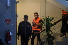 A Corruption Eradication Commission (KPK) investigator escorts Ponorogo Regent Sugiri Sancoko (right) following an interrogation on Nov. 9 at the KPK headquarters in Jakarta. Sugiri is accused of accepting bribes.
