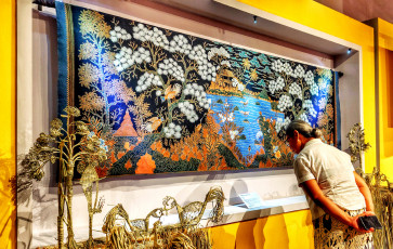 Cluck and contemplate: A visitor reads the caption beneath Batik Pemandangan Ayam Alas (2013) by Batik Sutoyo of Pekalongan, displayed at KukuruYUK!: Ragam Motif Ayam Dalam Batik Indonesia (KukuruYUK!: Various Chicken Motifs in Indonesian Batik) on Oct. 20 at the Museum Batik Indonesia in East Jakarta.