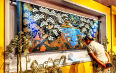 Cluck and contemplate: A visitor reads the caption beneath Batik Pemandangan Ayam Alas (2013) by Batik Sutoyo of Pekalongan, displayed at KukuruYUK!: Ragam Motif Ayam Dalam Batik Indonesia (KukuruYUK!: Various Chicken Motifs in Indonesian Batik) on Oct. 20 at the Museum Batik Indonesia in East Jakarta.
