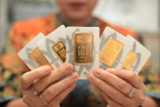 An employee holds up packets of gold bullion on Oct. 15, 2025, at the Butik Emas LM Antam outlet, a public gold vendor operated by state-owned miner PT Aneka Tambang (Antam), inside the Setiabudi One shopping mall in South Jakarta.