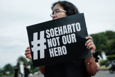 A member of a civil society movement holds a poster during a rally on Nov. 6 opposing the Indonesian government's plan to grant former president Soeharto a “National Hero“ title near the Presidential Palace in Jakarta. Former president Suharto, who died in 2008 aged 86, ruled Indonesia with an iron fist for more than three decades after grabbing power in 1967 following a failed military coup. The former military general's rule was marred by allegations of corruption and human rights abuses, including violent crackdowns on political dissent.