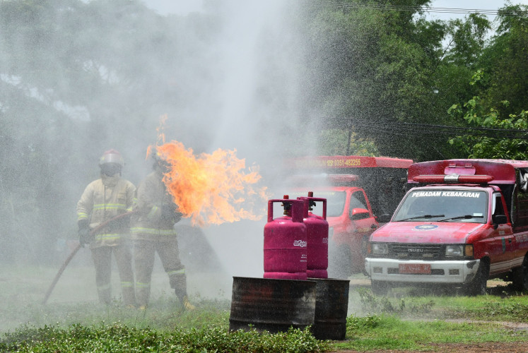 This is a drill: Firefighters extinguish flames during a fire prevention and response training session in Madiun, East Java, on Nov. 5, 2025. The exercise, joined by members of the Madiun Fire and Rescue Department, honed their skills and sharpened their readiness to handle emergencies.