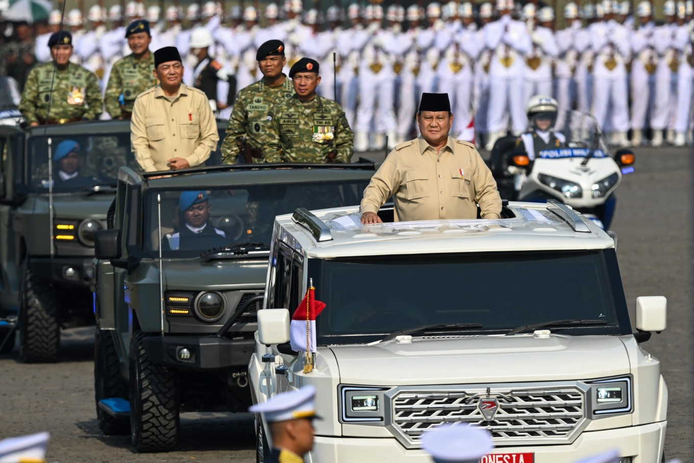 Patriotic pride: President Prabowo Subianto (front), accompanied by Defense Minister Sjafrie Sjamsoeddin (left, second row), Indonesian Military (TNI) commander Gen. Agus Subiyanto (right, second row) and other military leaders, inspects forces from his presidential vehicle in October ahead of a ceremony to celebrate the 80th anniversary of the TNI at the National Monument (Monas) complex in Central Jakarta. 