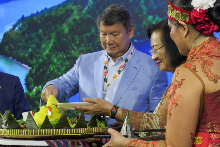 Special Presidential Envoy on Energy and Climate Change Hashim Djojohadikusumo (left) slices a 'tumpeng' (rice cone) on Nov. 10 during the opening ceremony of the Indonesian Pavilion at the United Nations climate change conference (COP30) in Belém, Brazil. The Indonesian delegation for the conference showcased climate mitigation and adaptation efforts in the pavilion throughout the two-week summit in the Brazilian town.