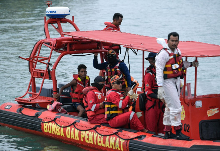 Malaysian rescuers approach a jetty after rescuing Rohingya migrant Iman Shorif (left), days after his boat carrying migrants from Myanmar capsized near the MalaysiaThailand border, in Langkawi on November 11, 2025. 