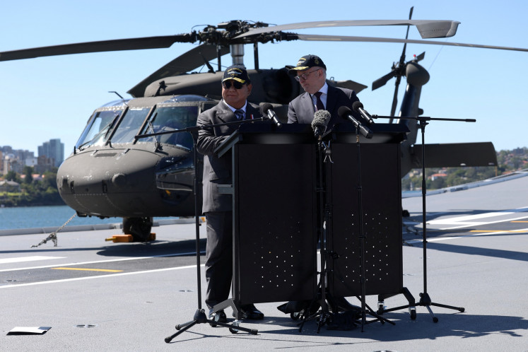 President Prabowo Subianto (left) and Australian Prime Minister Anthony Albanese react as a piece of paper blows off their lectern during a press conference on Nov. 12 on board HMAS Canberra in Sydney, Australia.