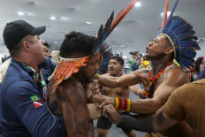 An indigenous demonstrator is held by a staff member on Nov. 11, 2025, as protesters force their way into the venue hosting the United Nations Climate Change Conference (COP30), in Belem, Brazil.