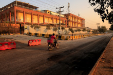 A food delivery rider rides past district court building with burned residue visible on a road, following a blast on November 11, in Islamabad, Pakistan November 13, 2025.