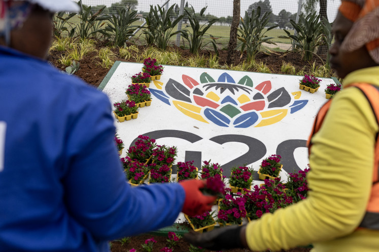 Blooms of hope: Workers plant flowers on Nov. 4 next to a sign for the 2025 G20 Johannesburg summit outside the NASREC Expo Centre, the venue of this year’s summit under South Africa’s Group of 20 presidency.