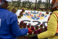 Blooms of hope: Workers plant flowers on Nov. 4 next to a sign for the 2025 G20 Johannesburg summit outside the NASREC Expo Centre, the venue of this year’s summit under South Africa’s Group of 20 presidency.