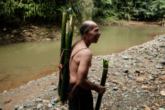 One man show: Ngigoro, 62, an elder of the O’Hongana Manyawa indigenous tribe who left the forest and now lives in a village with his mother, stands beside an allegedly contaminated river on April 16, 2025 in East Halmahera, North Maluku.