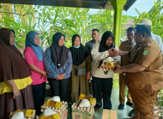 An official from the Rokan Hilir Fishery Agency ('right') hands over basic food items in this undated picture, to the families of 10 fishermen in Bagan Punak subdistrict, Bangko district, Riau. Malaysian authorities arrested the 10 fishermen when they crossed the maritime border on Nov. 5, 2025. 