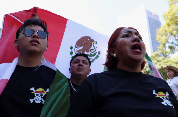 Demonstrators wear shirts showing the Jolly Roger pirate logo from Japanese series 'One Piece' as they take part in a march to protest against insecurity and corruption in the country in Mexico City, Mexico, on Nov. 15, 2025.