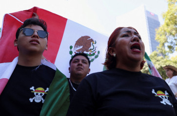 Demonstrators wear shirts showing the Jolly Roger pirate logo from Japanese series 'One Piece' as they take part in a march to protest against insecurity and corruption in the country in Mexico City, Mexico, on Nov. 15, 2025.