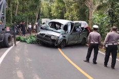 Traffic officers from the Buleleng Police monitor search and rescue efforts on Nov. 14, 2025, involving a Toyota HiAce van that fell into a ravine near Padang Bulia village in Sukasada district, Buleleng regency, northern Bali, killing five of 13 Chinese tourists who were traveling to Lovina Beach.