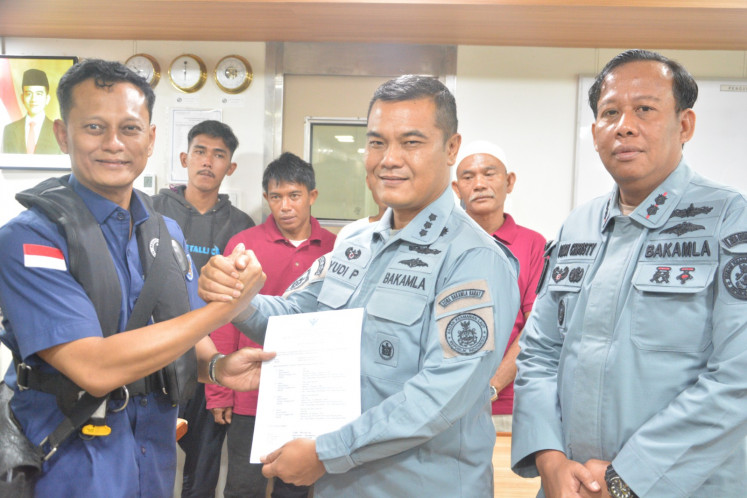 The Indonesian Maritime Security Agency (Bakamla) Western Zone head of operations Col. Yudi Priyatno (center) shakes hand with a diplomat from the Indonesian Consulate General in Johor Bahru (left) on Nov. 13, 2025, while flanked by KN Pulau Nipah-321 commander Lt. Col. Andy Christy Mahendra onboard the patrol vessel in the waters between Malaysia and Indonesia. The Bakamla patrol boat was picking up four fishermen arrested by the Malaysia Maritime Enforcement Agency (MMEA) for unintentionally crossing into Malaysian waters on Oct. 7, 2025.