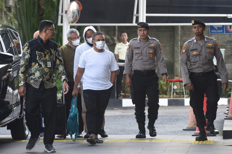 Riau Governor Abdul Wahid is escorted by police officers and Corruption Eradication Commission (KPK) investigators in front of the KPK headquarters in South Jakarta on Nov. 4, 2025. The KPK arrested the governor along with several senior provincial officials a day earlier during a raid in Riau. 