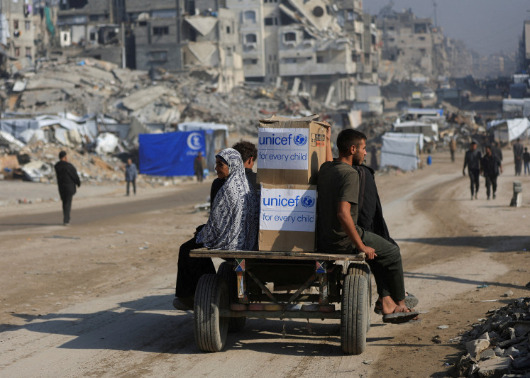 Palestinians transport relief materials on Tuesday amid a ceasefire between Israel and Hamas, in Gaza City. 