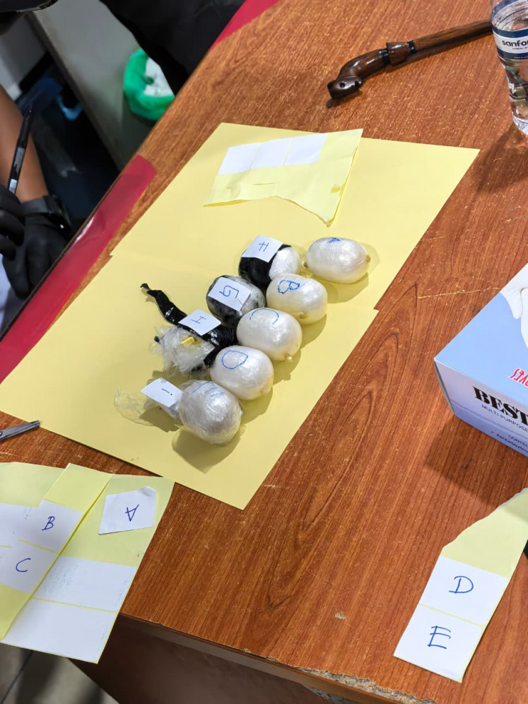 The Batam Customs and Excise Office displays 10 sacks containing 236 grams of sabu ( methamphetamine) and 256 ecstasy pills on Monday during a press conference in Batam, Riau Islands. The contraband was hidden in the anus of suspect MM, the customs office said.