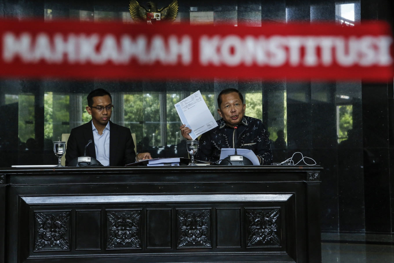 Constitutional Court Justice Arsul Sani (right), accompanied by court spokesperson Pan Mohamad Faiz (left), shows his academic documents during a press briefing on Monday at the court building in Jakarta. During the press briefing, Arsul denies allegations that he falsified his doctoral diploma to get the justice position at the Constitutional Court.
