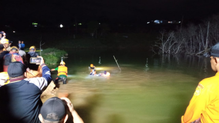 Rescuers from the Balikpapan Search and Rescue Agency in East Kalimantan dive into a water-filled pit near a construction site on Nov. 17  in North Balikpapan, Balikpapan City, East Kalimantan. They were searching for four of the six children who drowned while swimming in the pit.