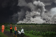 People look at a pyroclastic flow during the eruption of Mount Semeru in Lumajang, East Java, on November 19, 2025.