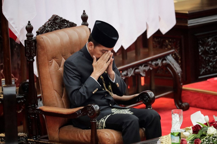 Former President Joko “Jokowi“ Widodo, wearing traditional Betawi attire, prays on Aug. 16, 2024, after delivering his State of the Nation Address during the annual People's Consultative Assembly (MPR) plenary session at the Senayan legislative complex in Jakarta