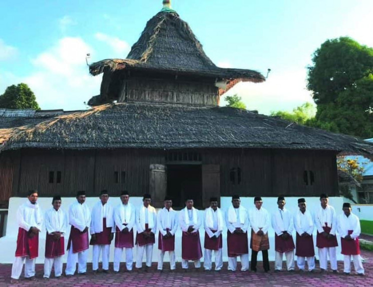 Craft guardians: Members of the Tukang Dua Belas (Tukang 12), or Tukan Husa Lua, pose in front of the Wapauwe Mosque in Kaitetu, Maluku. The council comprises craftsmen, customary chiefs and intermediaries who connect the artisans with local authorities. Each member holds specific skills, responsibilities and areas of expertise.