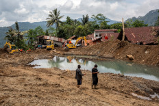 Residents walk at the site of a landslide in Situkung village, Banjarnegara, Central Java, on November 20, 2025.