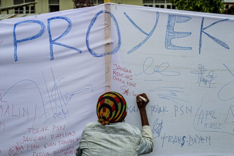 A participant signs a petition banner against the National Strategic Project (PSN) during the Merauke Solidarity Declaration at Petrus Vertenten Center in Merauke, South Papua on March 14, 2025. Keen to end its reliance on rice imports, Indonesia wants to plant vast tracts of the crop, along with sugar cane for biofuel, in the restive eastern region of Papua, a move environmentalists warn that it could become the world's largest deforestation project, threatening endangered species and the country's climate commitments.