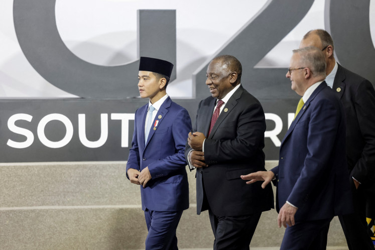 Vice President Gibran Rakabuming Raka, South Africa's President Cyril Ramaphosa and Australia's Prime Minister Anthony Albanese react on Saturday ahead of the family photo at the G20 Leaders' Summit at the Nasrec Expo Centre in Johannesburg, South Africa.