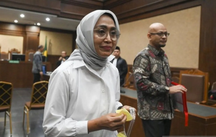 Defendants Ira Puspadewi (left), president director of state-owned PT ASDP Indonesia Ferry, and company director Harry Muhammad Adhi Caksono leave the courtroom after their indictment at the Jakarta Corruption Court on July 10, 2025.