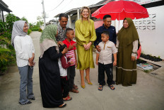 Queen Maxima of the Netherlands (center), in her capacity as the United Nations secretary general's special advocate for financial health (UNSGSA), poses for photos with residents on Wednesday during a visit to a subsidized housing complex for low-income families in Bekasi, West Java.