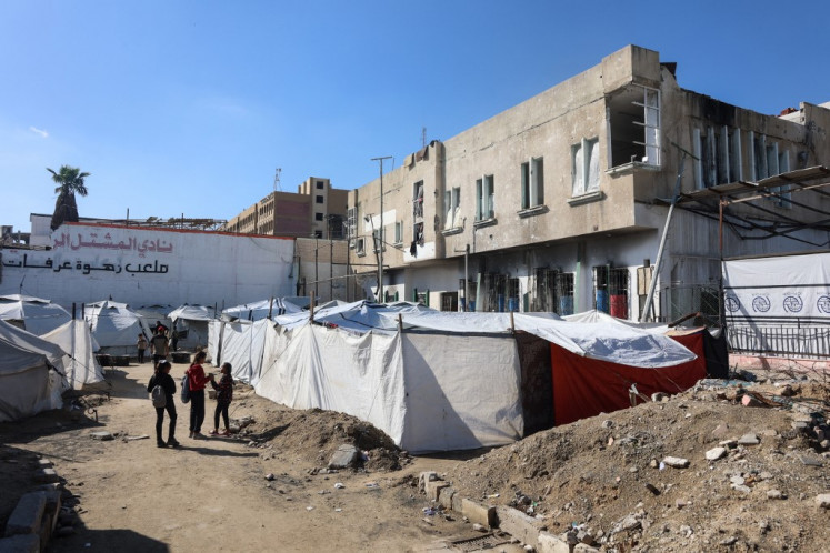 Palestinian children stand outside the partially damaged Al-Mushtal Sports Club on Nov. 26 in Gaza City.