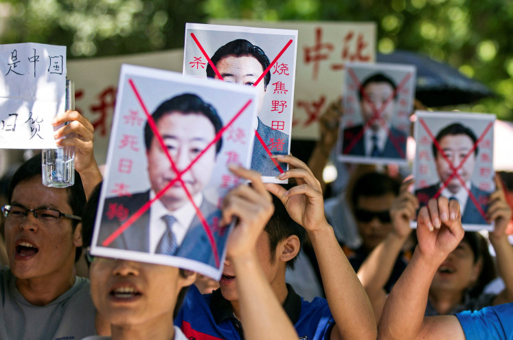 Demonstrators hold up crossed-out portraits of then-Japan prime minster Yoshihiko Noda during a protest in Nanning, Guangxi autonomous region, China, September 15, 2012.