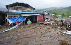 Residents navigate landslide debris on Nov. 27 in Nagari Malalak Timur village, Agam regency, West Sumatra, a day after a landslide struck. Severe weather in the province has triggered multiple landslides and floods, leaving 12 dead and affecting 12,000 people.