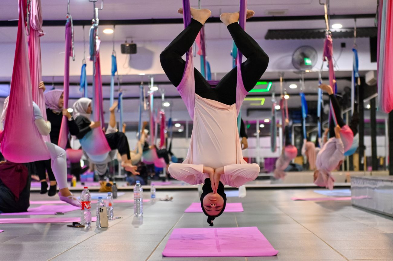 Peace of mind: Women practice aerial yoga on July 19, 2025 during a session at a gym for women in Banda Aceh, Aceh.  