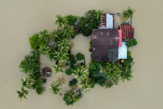 An aerial view shows a home surrounded by flood waters in Kangar in northern Malaysia's Perlis state on November 28, 2025, as severe flooding affected thousands of people in the region following days of heavy rain. The annual monsoon season, exacerbated by a tropical storm in the region in recent days, has inundated parts of southern Thailand, killing dozens and trapping many in their homes. In Malaysia, it also bought heavy flooding and killed at least two people. 